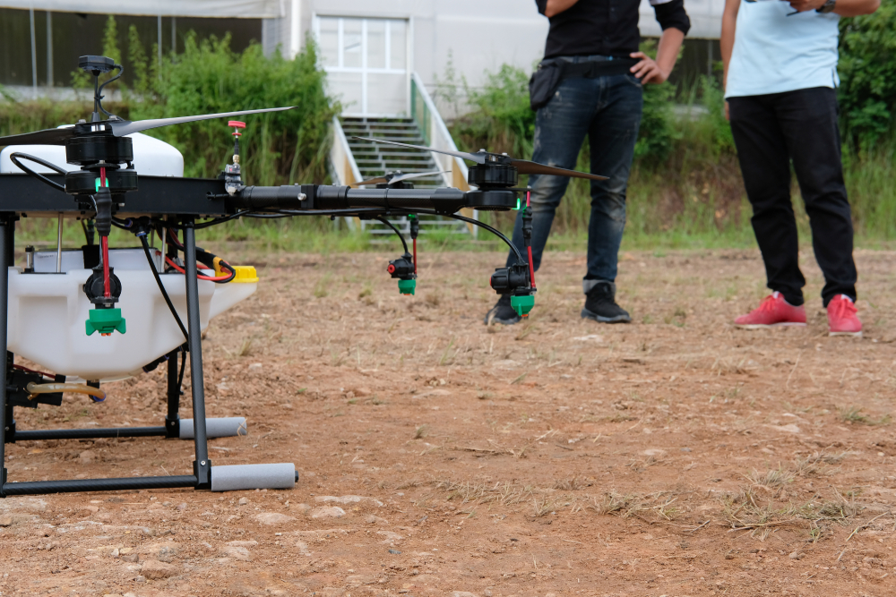 Two people getting drone ready for spraying liquid 